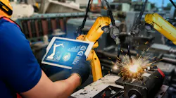 Man with tablet operating an industrial welding robot
