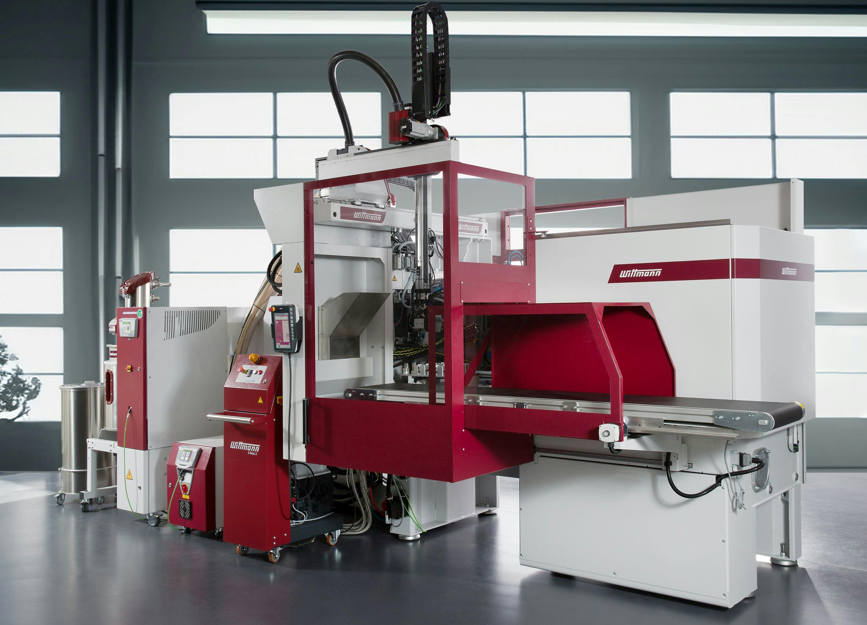 A Wittmann Ingrinder production cell for molding clamps and recycling scrap within the cell.