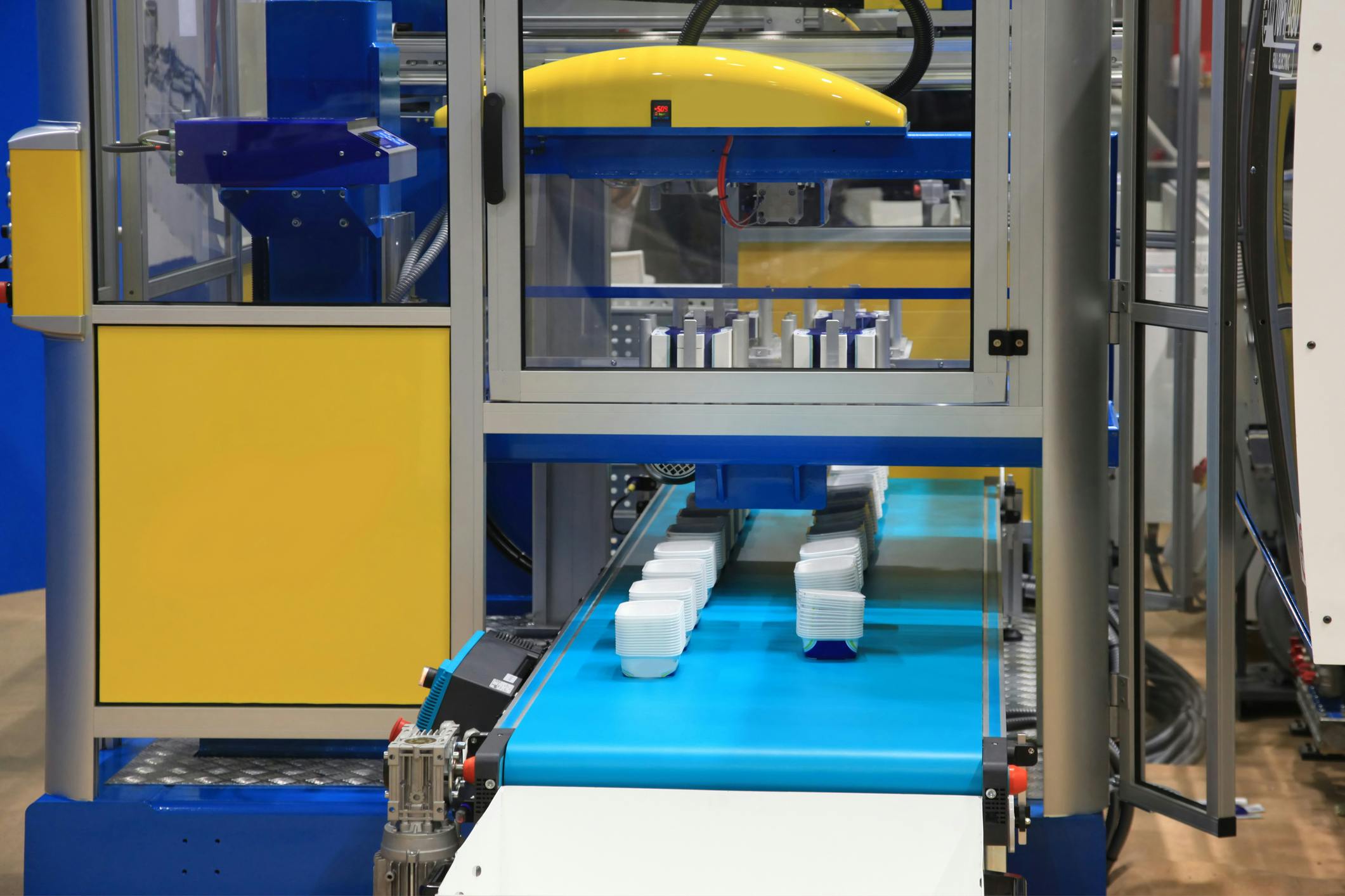 Plastic containers come off an injection molding line.