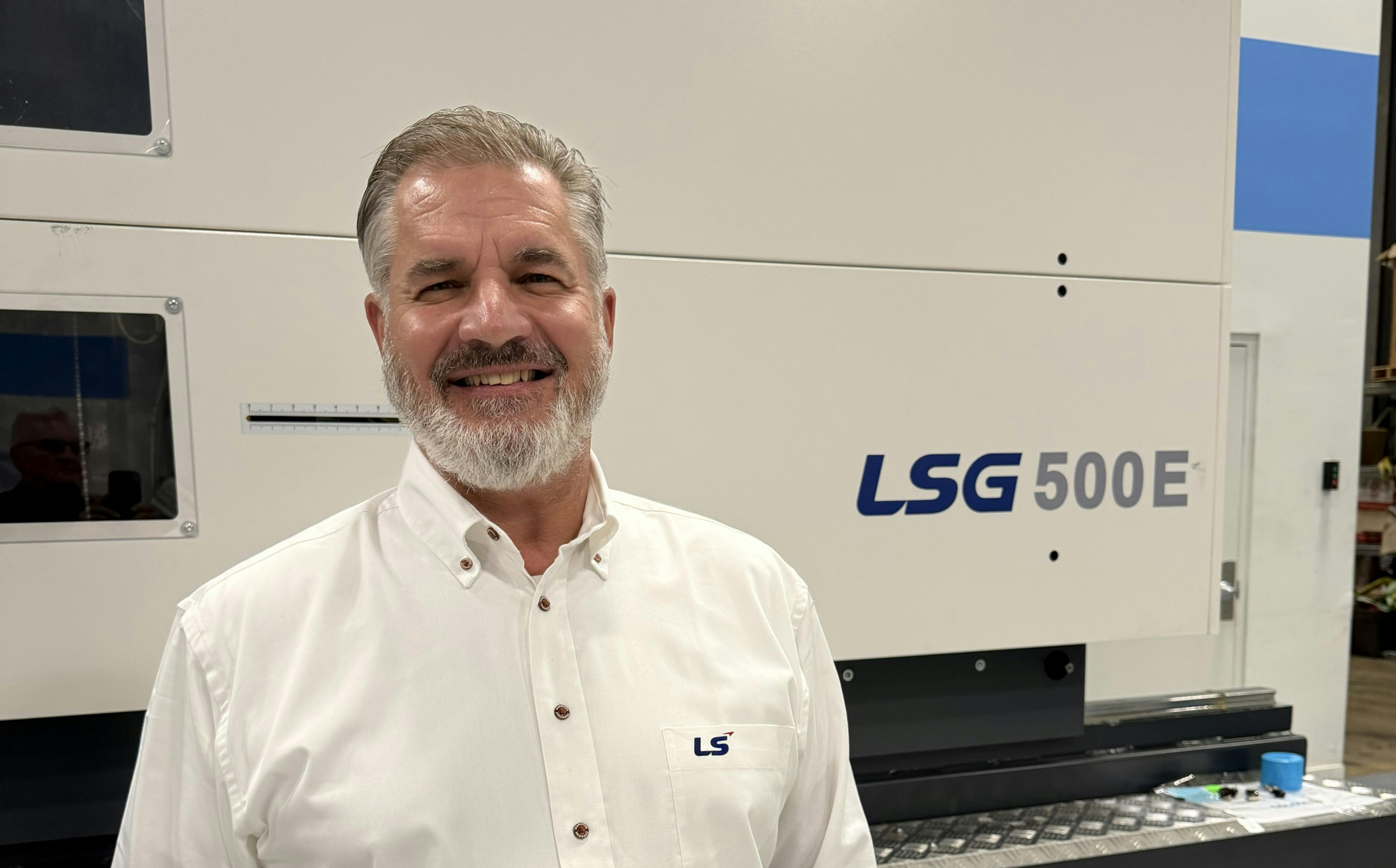 Robert Herman, U.S. Northeast regional sales manager for LS Mtron, standing in front of an injection molding machine..