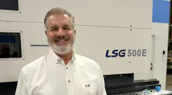 Robert Herman, U.S. Northeast regional sales manager for LS Mtron, standing in front of an injection molding machine..