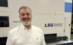 Robert Herman, U.S. Northeast regional sales manager for LS Mtron, standing in front of an injection molding machine..