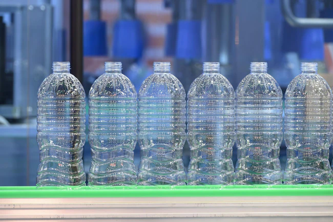 Blow molded beverage bottles on a production line.