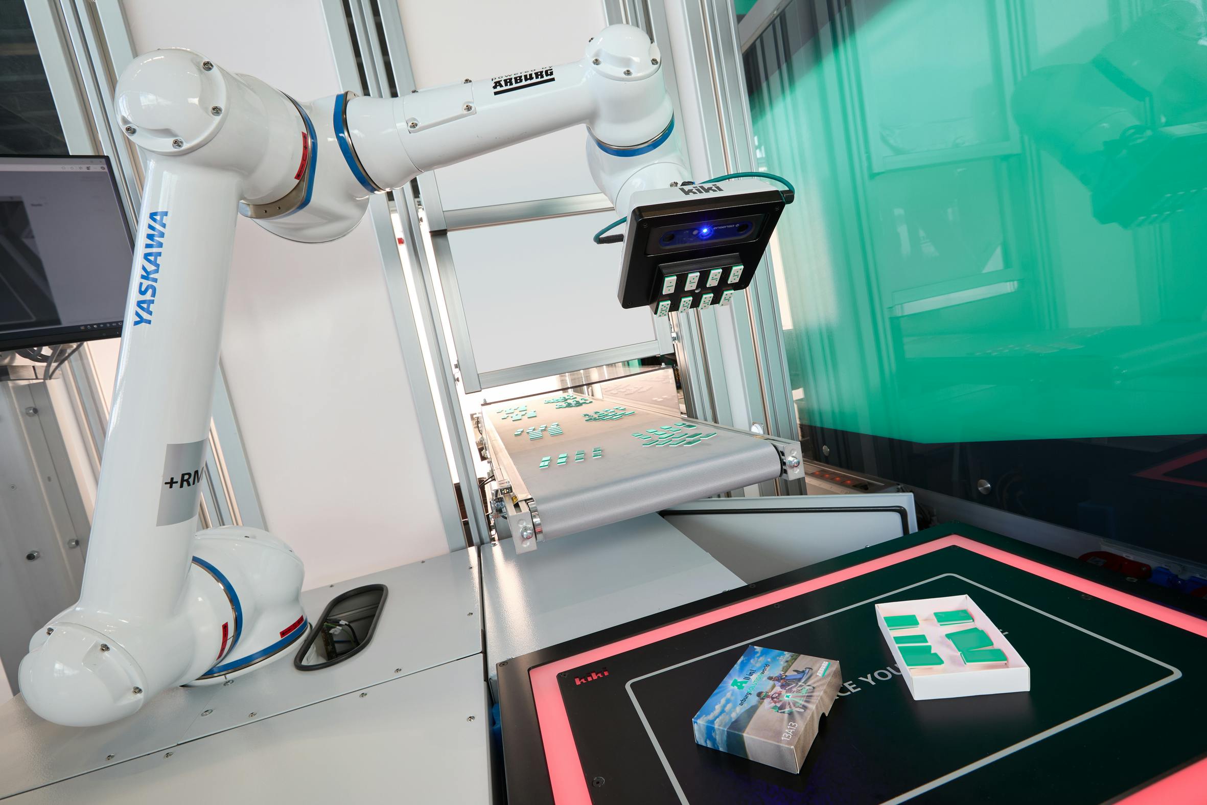 After a linear Multilift V 30 has placed 32 dominoes on a conveyor belt, a cobot takes over the subsequent packaging of the complete ready-to-use set of dominoes.