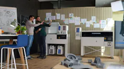 Two men examine a part printed by the HP MJF 1200