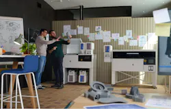 Two men examine a part printed by the HP MJF 1200