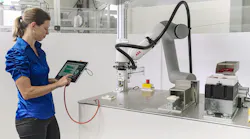 A woman operates a cobot using an E-Device and a tablet
