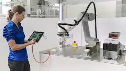 A woman operates a cobot using an E-Device and a tablet