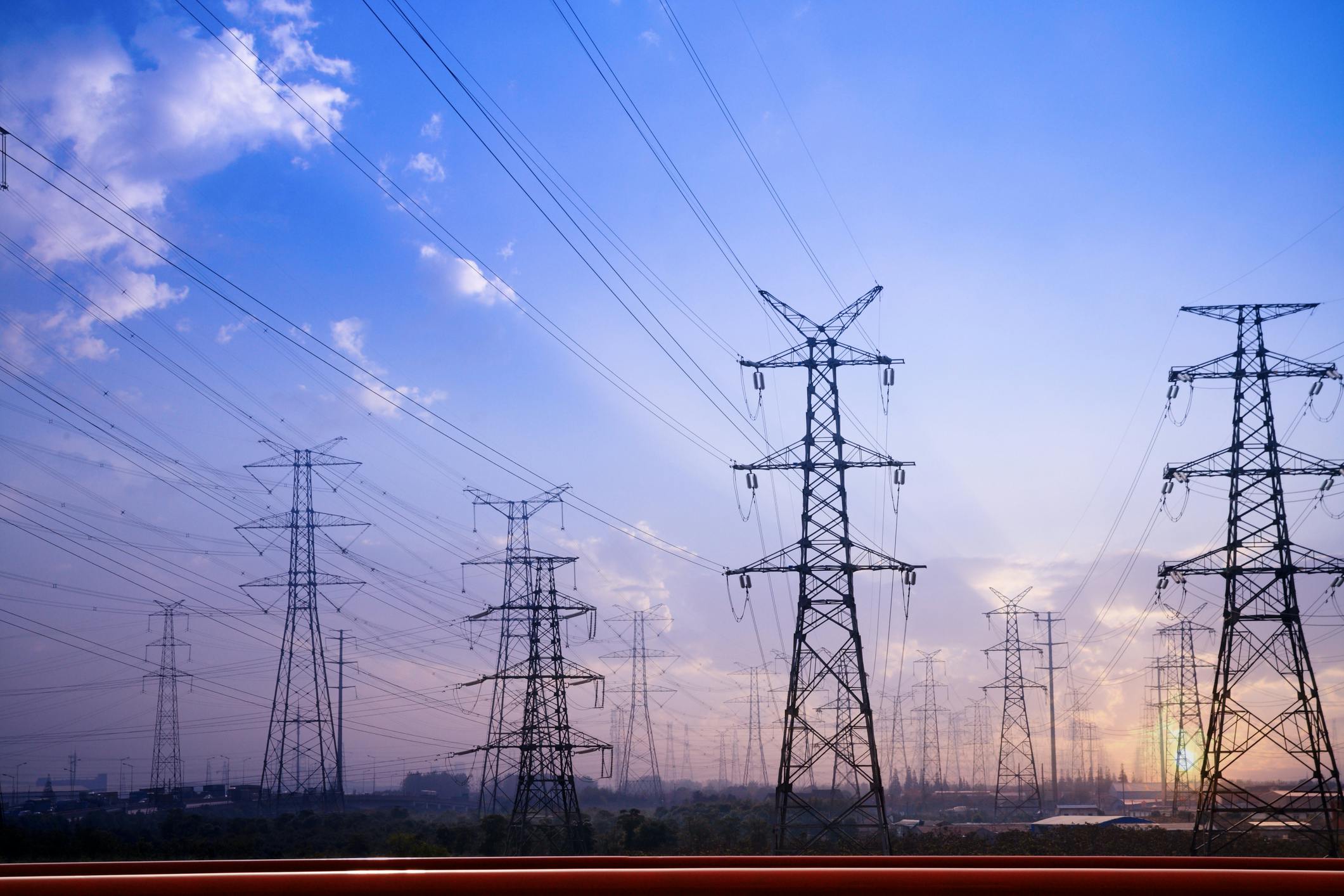 Image shows high voltage power lines against a twilight sky