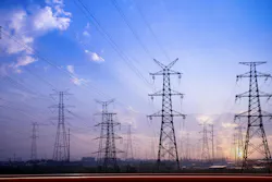 Image shows high voltage power lines against a twilight sky