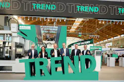 Arburg's management team poses behind a green sign for the 'Trend' machine