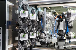 An injection mold opens with molded yogurt cups inside