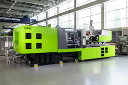 A green Engel E-motion injection molding machine on a factory floor