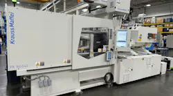 A white KraussMaffei injection molding machine on the company's floor.