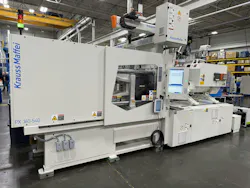 A white KraussMaffei injection molding machine on the company's floor.