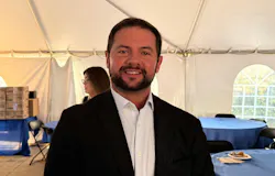 John Fini, president of KraussMaffei Corp., in a dark jacket and white shirt