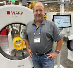 Peter Zut in gray shirt standing in front of Inoex machine for measuring pipes.
