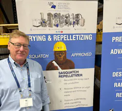Paul Carter of Advanced Blending Solutions in front of a banner promoting the company's Sasquatch pelletizers.