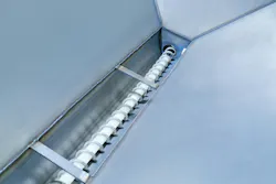 The hopper’s bottom features a U-shaped channel that exposes the flexible screw for the entire length of the vessel, allowing material entering the hopper at any point to charge the conveyor.