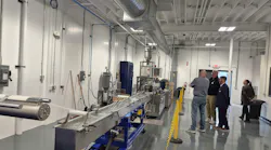 People watch a plastics strand pelletizer in action.